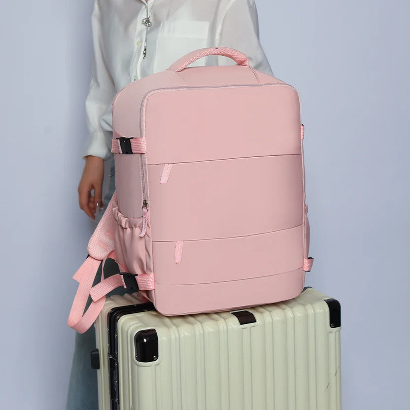 Mochila de viaje rosada sobre una maleta